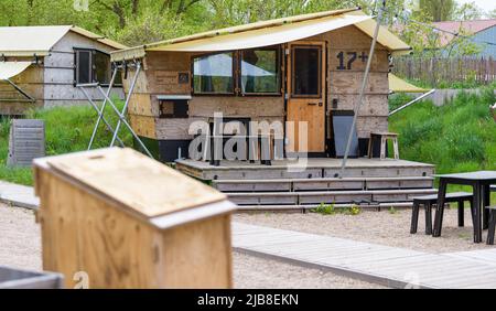 Hitzacker, Deutschland. 03.. Mai 2022. Holzhütten befinden sich im Zieldorf. Mini-Holzhütten laden zum Übernachten ein, ein Wellnessbereich mit Sauna zum Entspannen. Das Destinature Village erhielt dafür den Deutschen Tourismuspreis. (To dpa: Glamping in Hütten auf Stelzen im Destinature Village Hitzacker) Quelle: Philipp Schulze/dpa/Alamy Live News Stockfoto