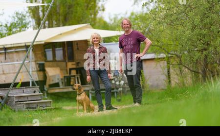 Hitzacker, Deutschland. 03.. Mai 2022. Eva und Holger Danneberg, Schöpfer und Besitzer des Schicksaldorfes, stehen im Schicksaldorf. Mini-Holzhütten laden zum Übernachten ein, und ein Wellnessbereich mit Sauna lädt zum Entspannen ein. Dafür erhielt das Zieldorf den Deutschen Tourismuspreis. (To dpa: Glamping in Hütten auf Stelzen im Zieldorf Hitzacker) Quelle: Philipp Schulze/dpa/Alamy Live News Stockfoto