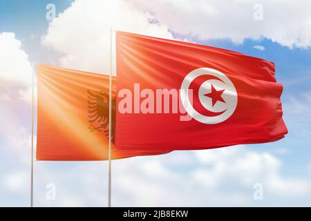 Sonniger blauer Himmel und Flaggen von tunesien und albanien Stockfoto