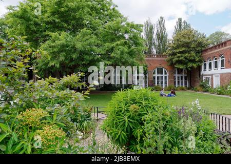 London, Greater London, England, Mai 28 2022: Auf dem Rasen neben der Orangerie im Holland Park in der Gegend von Kensington sitzen und entspannen. Stockfoto