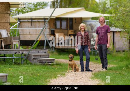 Hitzacker, Deutschland. 03.. Mai 2022. Eva und Holger Danneberg, Schöpfer und Besitzer des Schicksaldorfes, stehen im Schicksaldorf. Mini-Holzhütten laden zum Übernachten ein, und ein Wellnessbereich mit Sauna lädt zum Entspannen ein. Dafür erhielt das Zieldorf den Deutschen Tourismuspreis. (To dpa: Glamping in Hütten auf Stelzen im Zieldorf Hitzacker) Quelle: Philipp Schulze/dpa/Alamy Live News Stockfoto