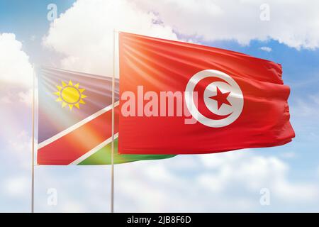 Sonniger blauer Himmel und Flaggen von tunesien und namibia Stockfoto