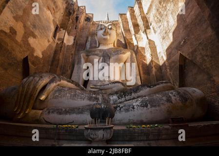 Alte riesige Skulptur eines sitzenden Buddha (Phra Achana) in den Ruinen des buddhistischen Tempels Wat Si Chum. Sukhotai, Thailand Stockfoto