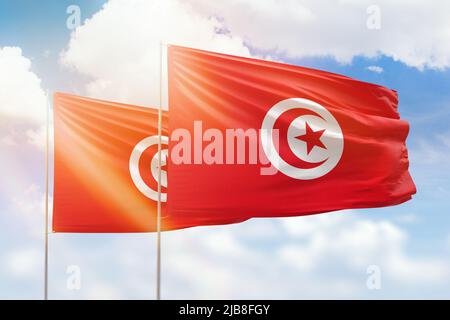 Sonniger blauer Himmel und Flaggen von tunesien und tunesien Stockfoto
