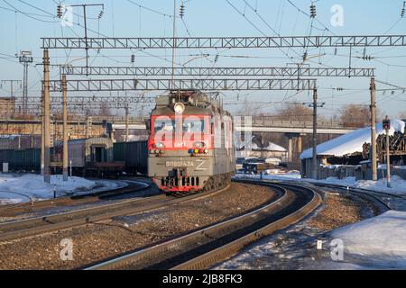 SHARYA, RUSSLAND - 19. MÄRZ 2022: Elektrische Lokomotive VL80S-434 mit Güterzug fährt an einem Märztag vom Bahnhof ab Stockfoto