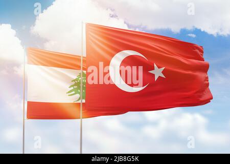 Sonniger blauer Himmel und Flaggen der türkei und des libanon Stockfoto