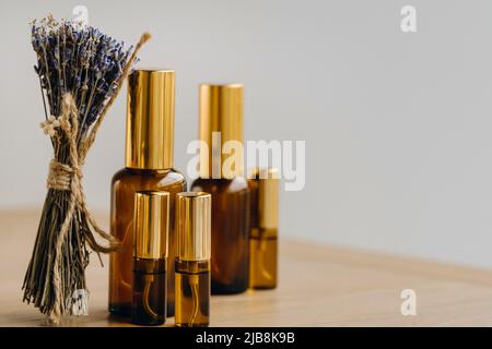 Ätherisches Öl in einer Flasche und getrockneter Lavendel auf der Oberfläche Stockfoto