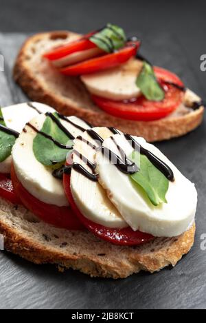 Offene Sandwiches, in der Mitte des Brettes ein offenes Avocado-Sandwich aus Sauerteig-Brot mit dem Zusatz von Kirschtomaten, Mini-Mozzarell Stockfoto