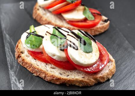 Caprese Bruschetta Toasts mit Tomaten, Mozzarella und Basilikum. Draufsicht mit Platz für Ihren Text. Stockfoto