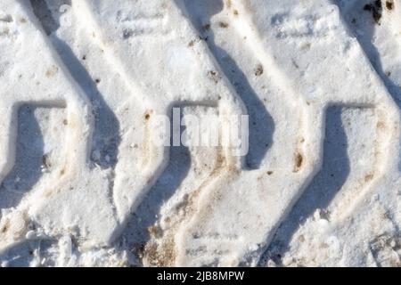 Schneereifenmarkierung. Reifenprofilmarkierungen. Schnee bedeckte den Boden. Gefährliche Straßenbedingungen. Autoabdruck auf gefrorenem Boden. Tiefer Trail von der Lauffläche einer SU Stockfoto