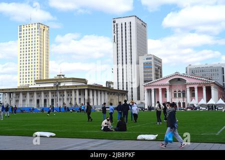 Ulaanbaatar, Mongolei - 11. Mai 2022: Junge Mongolen ruhen sich aus und kommunizieren miteinander auf einem Fußballplatz im Zentrum des Sukhbaatar-Squars Stockfoto