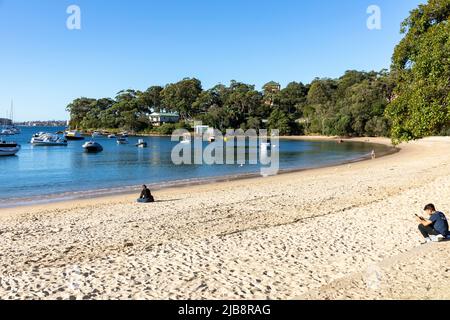 Balmoral Beach Mosman und ein blauer Himmel sonnigen Wintertag in Sydney, NSW, Australien Person sitzt auf dem Sand Stockfoto