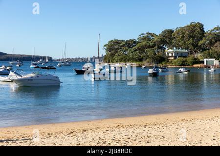 Balmoral Beach in der Sydney Gegend von Mosman an einem sonnigen Wintertag, Sydney, NSW, Australien mit Booten, die in der Bucht festgemacht sind Stockfoto