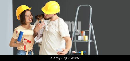 Junges Paar mit niedlichen Hund machen Reparatur im Zimmer Stockfoto