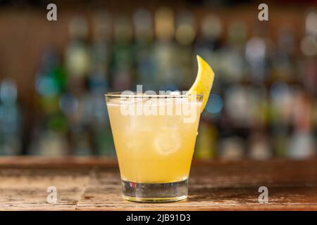 Penicillin-Cocktail an der Bar. Verschwommener Hintergrund.erfrischendes Getränk im Sommer, Seitenansicht, Nahaufnahme. Stockfoto