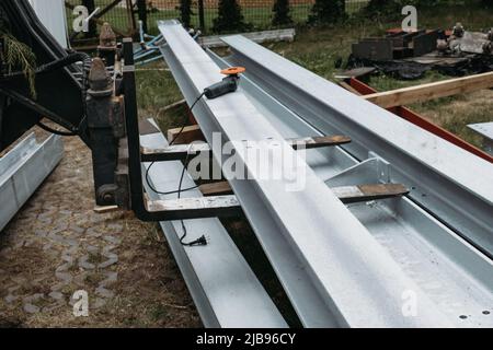 Metallträger, silberfarbener Träger mit Schrauben, saubere Metallkonstruktion. Der Aufzug trägt eine schwere Metallstruktur. Nahaufnahme des industriellen Hubgerüst. Stockfoto