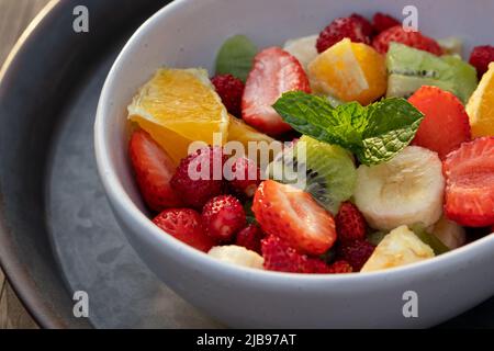 Obstsalat in einer weißen Schüssel auf einem Metalltablett Stockfoto