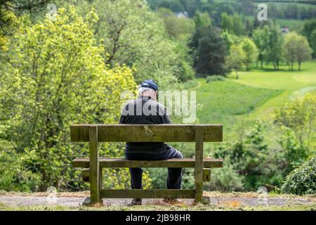 Brecon, 14. 2022. Mai: Ein Mann auf einer Bank mit Blick auf den Fluss Usk in Brecon Stockfoto