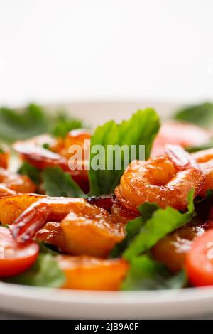 Nahaufnahme von frischen Garnelen, Tomaten, Rucola und grünem Salat, vertikales Bild mit Kopierfläche. Stockfoto