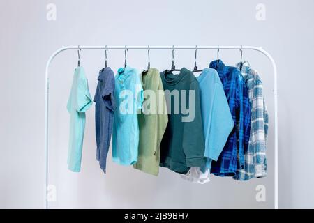 Gestell mit stylischer Kinderkleidung auf Kleiderbügeln für einen Jungen im Vorschulalter. Kleiderschrank für einen kleinen Jungen. Stockfoto