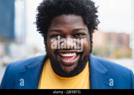 Glücklicher afrikanischer Mann, der vor der Kamera im Freien lächelt Stockfoto