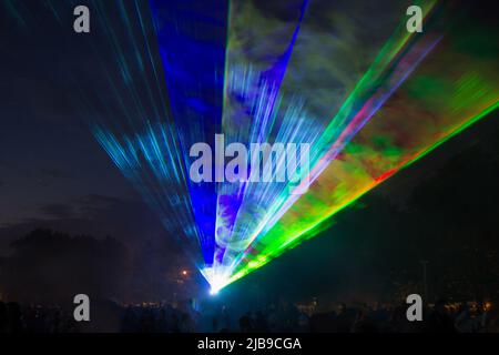 Grüne und blaue Laserstrahlen in einem Stadtpark Stockfoto