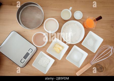 Eine Reihe von Zutaten und Werkzeugen zum Backen eines Orangenkuchens. Stockfoto