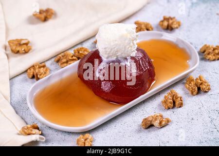 Quitte-Dessert. Traditionelle türkische Küche Delikatessen. Quitte-Dessert mit Creme auf steinernem Hintergrund. Nahaufnahme. Lokaler Name ayva tatlisi Stockfoto