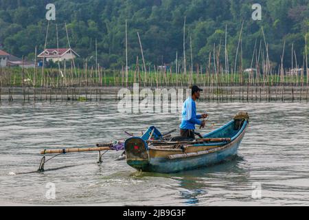 Binangonan, Philippinen. 04.. Juni 2022. Ein Fischer rudert sein Boot aus, um eine Chance auf den Fang eines Fisches zu nehmen. Laguna Lake ist der größte See auf den Philippinen und bedeckt eine Fläche von 900 Quadratkilometern oder entspricht 90.000 Hektar. Das Wasser fließt von der Provinz Laguna bis zur Provinz Rizal, dem südlichen Teil von Luzon. Der See bietet Ressourcen wie Transport, Erholung, Lebensunterhalt und vor allem Nahrung für die umliegenden Gemeinden. Laguna Lake wird als Süßwasser der Klasse C klassifiziert, das die Fähigkeit besitzt, Fische und andere aquatische Ressourcen anzubauen. Etwas Wasser Stockfoto