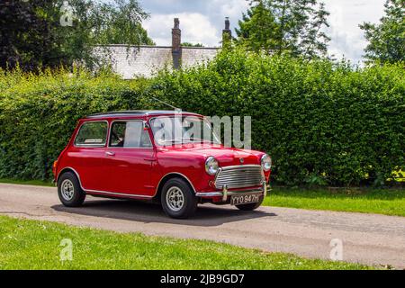 1970 70s 70er Jahre rot Morris Mini Cooper 998 ccm Benzin kleiner Stadtwagen Ankunft in worden Park Motor Village für das Leyland Festival, Großbritannien Stockfoto