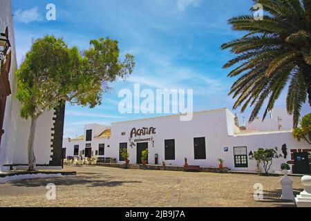 Teguise, Lanzarote - Juin 3. 2019: Wunderschöne weiße, ruhige kanarische Stadt, traditionelles Restauranthaus, leerer Platz mit Palmen, blauer Himmel Stockfoto