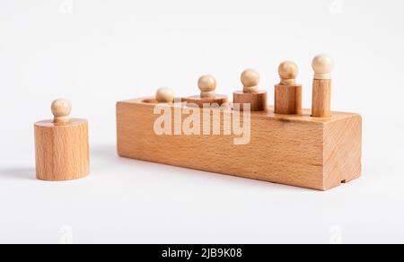 Montessori geklopft Holzzylinder falsch in Block platziert. Fehler in der Puzzle-Baugruppe. Kinder Spiel für die Entwicklung der Dimension Wahrnehmung. Hochwertige Fotos Stockfoto