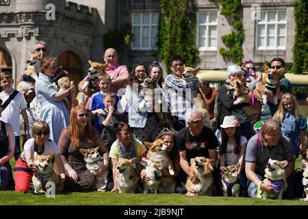 Corgis und ihre Besitzer auf dem Rasen in Balmoral während einer Veranstaltung mit der Corgi Society of Scotland anlässlich des Platin-Jubiläums von Königin Elizabeth II. Das Schloss in Aberdeenshire ist das Ferienhaus aus dem 19.. Jahrhundert, in dem die Königin und Mitglieder der königlichen Familie jedes Jahr zwischen August und September ihren traditionellen Urlaub verbringen. Bilddatum: Samstag, 4. Juni 2022. Stockfoto