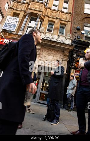 Menschen, die am heißen Sommertag vor dem Red Lion Pub in der Duke of York St, St James, London stehen Stockfoto