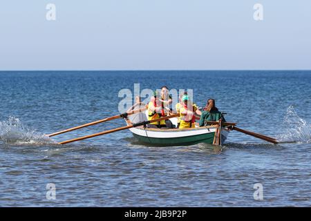 Troon, Großbritannien. 04.. Juni 2022. 04. Juni 2022. Troon, Großbritannien. Der Troon Coastal Rowing Club (TCRC) veranstaltete seine jährliche Regatta auf dem Firth of Clyde, der vom Südstrand Troon, Ayrshire, Großbritannien, aus segelte. Die kleinen Boote sind traditionell, handgefertigt, aus Holz, 4 Crew, Angeln Skiffs, Basierend auf einem 300 Jahre alten Design. Das Rennen erfordert, dass die Teilnehmer eine festgelegte Strecke von nicht weniger als 2 Kilometern zurücklegen, vom Ufer aus und bei der Rückkehr muss ein Teammitglied einen Stock Troon Rock (Süßwaren}) nehmen und mit ihm bis zur Ziellinie laufen. Die Veranstaltung zog Teilnehmer aus verschiedenen Ruderclubs an der Küste Schottlands an Stockfoto