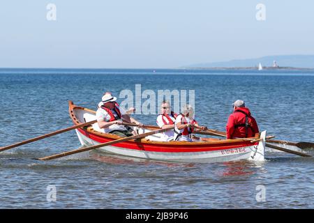 Troon, Großbritannien. 04.. Juni 2022. 04. Juni 2022. Troon, Großbritannien. Der Troon Coastal Rowing Club (TCRC) veranstaltete seine jährliche Regatta auf dem Firth of Clyde, der vom Südstrand Troon, Ayrshire, Großbritannien, aus segelte. Die kleinen Boote sind traditionell, handgefertigt, aus Holz, 4 Crew, Angeln Skiffs, Basierend auf einem 300 Jahre alten Design. Das Rennen erfordert, dass die Teilnehmer eine festgelegte Strecke von nicht weniger als 2 Kilometern zurücklegen, vom Ufer aus und bei der Rückkehr muss ein Teammitglied einen Stock Troon Rock (Süßwaren}) nehmen und mit ihm bis zur Ziellinie laufen. Die Veranstaltung zog Teilnehmer aus verschiedenen Ruderclubs an der Küste Schottlands an Stockfoto