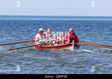 Troon, Großbritannien. 04.. Juni 2022. 04. Juni 2022. Troon, Großbritannien. Der Troon Coastal Rowing Club (TCRC) veranstaltete seine jährliche Regatta auf dem Firth of Clyde, der vom Südstrand Troon, Ayrshire, Großbritannien, aus segelte. Die kleinen Boote sind traditionell, handgefertigt, aus Holz, 4 Crew, Angeln Skiffs, Basierend auf einem 300 Jahre alten Design. Das Rennen erfordert, dass die Teilnehmer eine festgelegte Strecke von nicht weniger als 2 Kilometern zurücklegen, vom Ufer aus und bei der Rückkehr muss ein Teammitglied einen Stock Troon Rock (Süßwaren}) nehmen und mit ihm bis zur Ziellinie laufen. Die Veranstaltung zog Teilnehmer aus verschiedenen Ruderclubs an der Küste Schottlands an Stockfoto