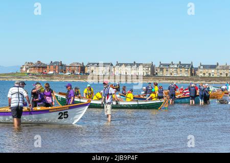 Troon, Großbritannien. 04.. Juni 2022. 04. Juni 2022. Troon, Großbritannien. Der Troon Coastal Rowing Club (TCRC) veranstaltete seine jährliche Regatta auf dem Firth of Clyde, der vom Südstrand Troon, Ayrshire, Großbritannien, aus segelte. Die kleinen Boote sind traditionell, handgefertigt, aus Holz, 4 Crew, Angeln Skiffs, Basierend auf einem 300 Jahre alten Design. Das Rennen erfordert, dass die Teilnehmer eine festgelegte Strecke von nicht weniger als 2 Kilometern zurücklegen, vom Ufer aus und bei der Rückkehr muss ein Teammitglied einen Stock Troon Rock (Süßwaren}) nehmen und mit ihm bis zur Ziellinie laufen. Die Veranstaltung zog Teilnehmer aus verschiedenen Ruderclubs an der Küste Schottlands an Stockfoto