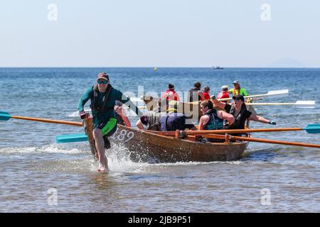 Troon, Großbritannien. 04.. Juni 2022. 04. Juni 2022. Troon, Großbritannien. Der Troon Coastal Rowing Club (TCRC) veranstaltete seine jährliche Regatta auf dem Firth of Clyde, der vom Südstrand Troon, Ayrshire, Großbritannien, aus segelte. Die kleinen Boote sind traditionell, handgefertigt, aus Holz, 4 Crew, Angeln Skiffs, Basierend auf einem 300 Jahre alten Design. Das Rennen erfordert, dass die Teilnehmer eine festgelegte Strecke von nicht weniger als 2 Kilometern zurücklegen, vom Ufer aus und bei der Rückkehr muss ein Teammitglied einen Stock Troon Rock (Süßwaren}) nehmen und mit ihm bis zur Ziellinie laufen. Die Veranstaltung zog Teilnehmer aus verschiedenen Ruderclubs an der Küste Schottlands an Stockfoto