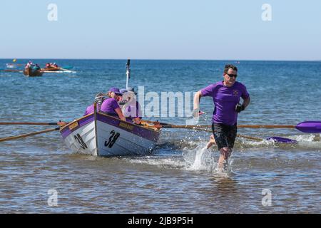 Troon, Großbritannien. 04.. Juni 2022. 04. Juni 2022. Troon, Großbritannien. Der Troon Coastal Rowing Club (TCRC) veranstaltete seine jährliche Regatta auf dem Firth of Clyde, der vom Südstrand Troon, Ayrshire, Großbritannien, aus segelte. Die kleinen Boote sind traditionell, handgefertigt, aus Holz, 4 Crew, Angeln Skiffs, Basierend auf einem 300 Jahre alten Design. Das Rennen erfordert, dass die Teilnehmer eine festgelegte Strecke von nicht weniger als 2 Kilometern zurücklegen, vom Ufer aus und bei der Rückkehr muss ein Teammitglied einen Stock Troon Rock (Süßwaren}) nehmen und mit ihm bis zur Ziellinie laufen. Die Veranstaltung zog Teilnehmer aus verschiedenen Ruderclubs an der Küste Schottlands an Stockfoto