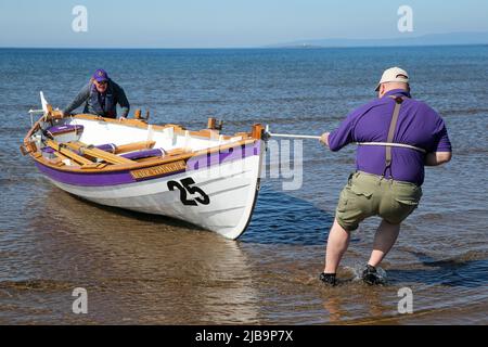 Troon, Großbritannien. 04.. Juni 2022. 04. Juni 2022. Troon, Großbritannien. Der Troon Coastal Rowing Club (TCRC) veranstaltete seine jährliche Regatta auf dem Firth of Clyde, der vom Südstrand Troon, Ayrshire, Großbritannien, aus segelte. Die kleinen Boote sind traditionell, handgefertigt, aus Holz, 4 Crew, Angeln Skiffs, Basierend auf einem 300 Jahre alten Design. Das Rennen erfordert, dass die Teilnehmer eine festgelegte Strecke von nicht weniger als 2 Kilometern zurücklegen, vom Ufer aus und bei der Rückkehr muss ein Teammitglied einen Stock Troon Rock (Süßwaren}) nehmen und mit ihm bis zur Ziellinie laufen. Die Veranstaltung zog Teilnehmer aus verschiedenen Ruderclubs an der Küste Schottlands an Stockfoto