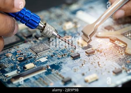 Techniker repariert die Leiterplatteninnenseite mit einem Lötkolben. Integrated Circuit. Das Konzept von Daten, Hardware, Techniker und Technolo Stockfoto