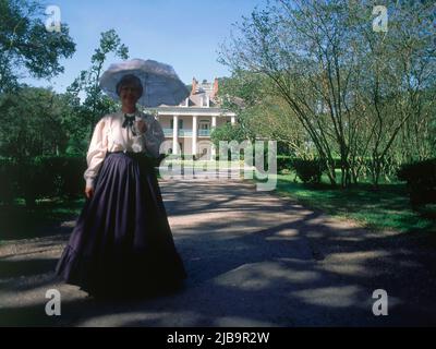 EXT-MUJER VESTIDA DE EPOCA ANTE LA MANSION CONSTRUIDA EN 1837 EN ESTILO NEOCLASICO PARA J.T.ROMAN. Autor: SWAINEY GEORGE. Lage: PLANTACION OAKALLEY. BATON ROUGE-LUISIANA. Stockfoto