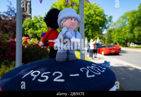 Ballater, Schottland, Großbritannien. 4. Juni 2022. Das Platin-Jubiläum der Königin wird im Dorf Ballater in der Nähe von Balmoral auf der Royal Deeside in Aberdeenshire gefeiert. PIC; eine „Box Topper“ gehäkelte Königin, die einen königlichen Haftbefehl auf eine Postsäule im Dorf ausgibt. Iain Masterton/Alamy Live News Stockfoto