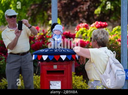 Ballater, Schottland, Großbritannien. 4. Juni 2022. Das Platin-Jubiläum der Königin wird im Dorf Ballater in der Nähe von Balmoral auf der Royal Deeside in Aberdeenshire gefeiert. PIC; eine „Box Topper“ gehäkelte Königin, die einen königlichen Haftbefehl auf eine Postsäule im Dorf ausgibt. Iain Masterton/Alamy Live News Stockfoto