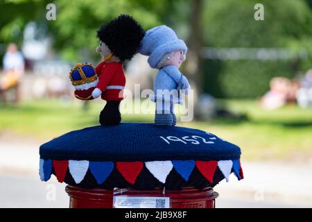 Ballater, Schottland, Großbritannien. 4. Juni 2022. Das Platin-Jubiläum der Königin wird im Dorf Ballater in der Nähe von Balmoral auf der Royal Deeside in Aberdeenshire gefeiert. PIC; eine „Box Topper“ gehäkelte Königin, die einen königlichen Haftbefehl auf eine Postsäule im Dorf ausgibt. Iain Masterton/Alamy Live News Stockfoto