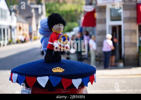 Ballater, Schottland, Großbritannien. 4. Juni 2022. Das Platin-Jubiläum der Königin wird im Dorf Ballater in der Nähe von Balmoral auf der Royal Deeside in Aberdeenshire gefeiert. PIC; eine „Box Topper“ gehäkelte Königin, die einen königlichen Haftbefehl auf eine Postsäule im Dorf ausgibt. Iain Masterton/Alamy Live News Stockfoto