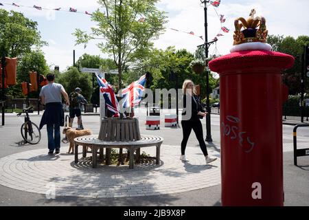 Eine gehäkelte Strickkrone sitzt am 4.. Juni 2022 in London, England, auf einer Royal Mail-Briefbox im Dorf Dulwich während des Feiertagswochenendes zur Feier des Platin-Jubiläums der Königin. Königin Elizabeth II. Steht seit 70 Jahren auf dem britischen Thron, der dienstältesten Monarchin der englischen Geschichte, und während des Jubiläumswochenendes organisiert die Öffentlichkeit Straßenfeste und Gemeindeveranstaltungen. Stockfoto