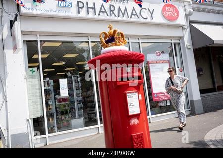 Eine gehäkelte Strickkrone sitzt am 4.. Juni 2022 in London, England, auf einer Royal Mail-Briefbox im Dorf Dulwich während des Feiertagswochenendes zur Feier des Platin-Jubiläums der Königin. Königin Elizabeth II. Steht seit 70 Jahren auf dem britischen Thron, der dienstältesten Monarchin der englischen Geschichte, und während des Jubiläumswochenendes organisiert die Öffentlichkeit Straßenfeste und Gemeindeveranstaltungen. Stockfoto