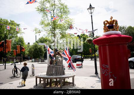 Eine gehäkelte Strickkrone sitzt am 4.. Juni 2022 in London, England, auf einer Royal Mail-Briefbox im Dorf Dulwich während des Feiertagswochenendes zur Feier des Platin-Jubiläums der Königin. Königin Elizabeth II. Steht seit 70 Jahren auf dem britischen Thron, der dienstältesten Monarchin der englischen Geschichte, und während des Jubiläumswochenendes organisiert die Öffentlichkeit Straßenfeste und Gemeindeveranstaltungen. Stockfoto